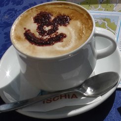 ein Cappuccino mit geschäumter Milch und einem Lächeln aus Kakao
