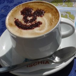 ein Cappuccino mit geschäumter Milch und einem Lächeln aus Kakao