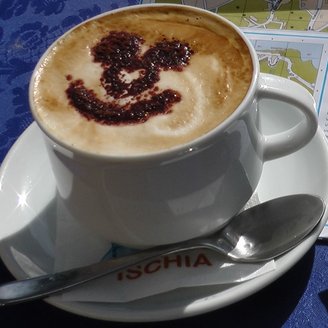 ein Cappuccino mit geschäumter Milch und einem Lächeln aus Kakao
