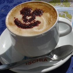 ein Cappuccino mit geschäumter Milch und einem Lächeln aus Kakao